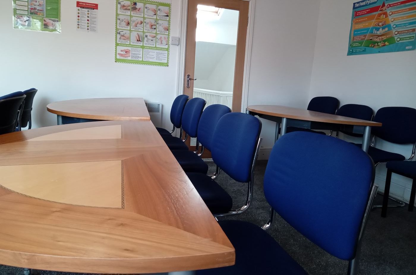 Training room with tables, blue chairs and teaching posters on the walls